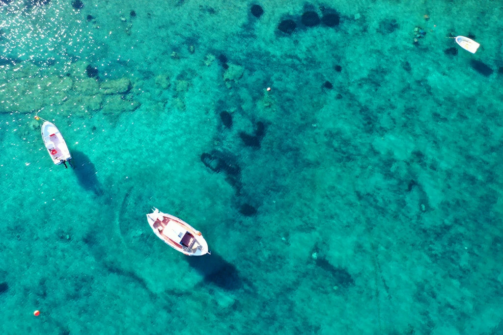 türkisfarbenes Meer auf Koufonisia mit Booten