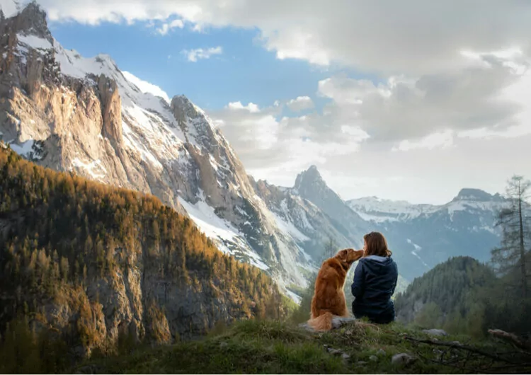 Junge Frau mit Hund genießt die schöne Aussicht