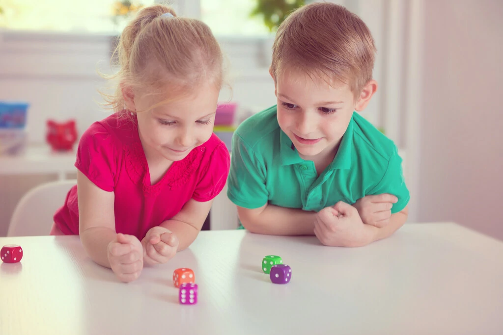 Kinder spielen mit Würfeln auf dem Boden