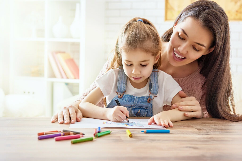 Mutter und Tochter mit Papier und Stiften