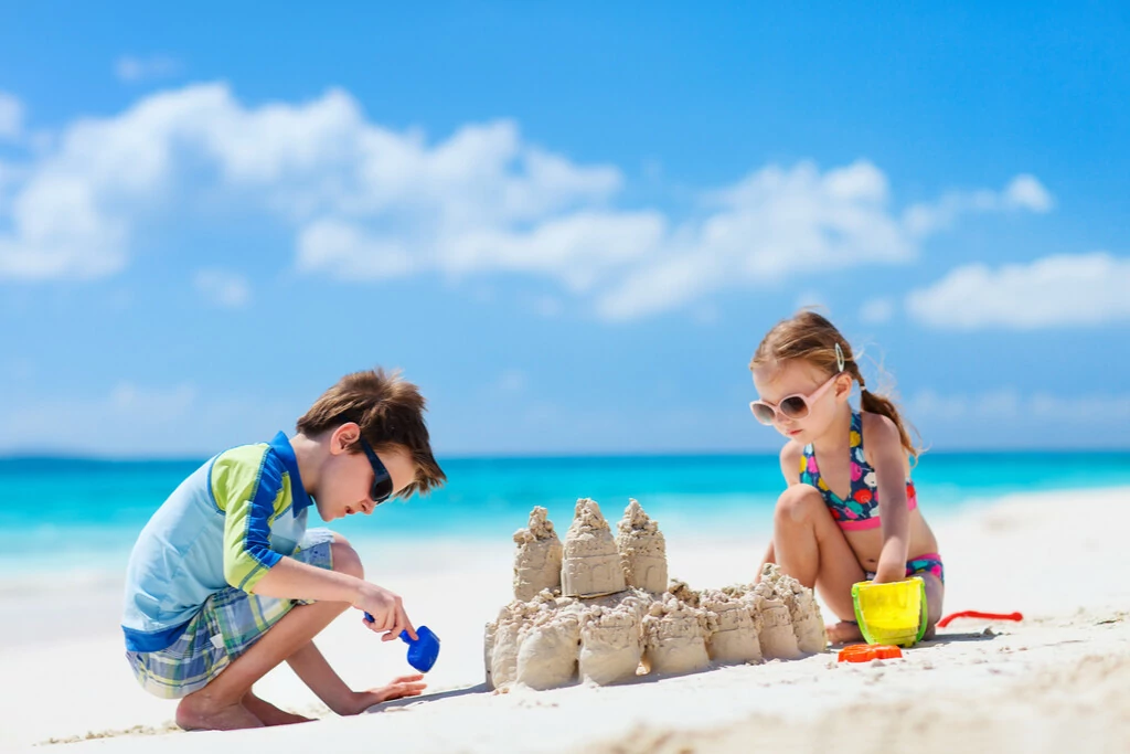 Kinder spielen mit Wasser und Sand