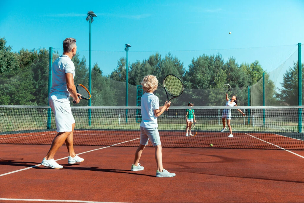 Familie spielt Tennis gegeneinander