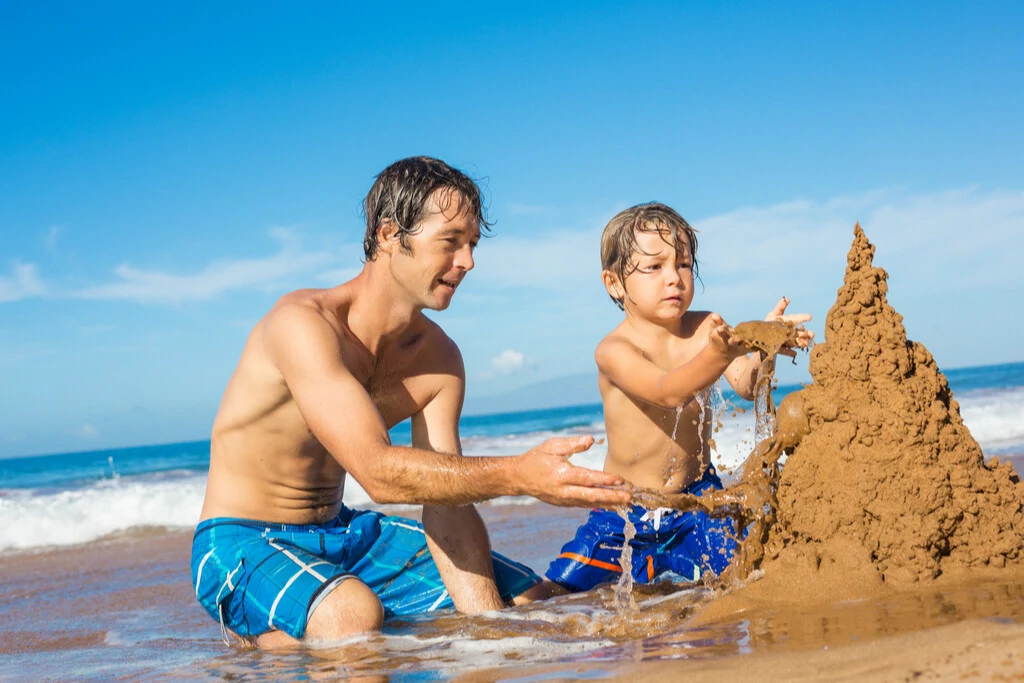 Vater und Sohn bauen eine Sandburg