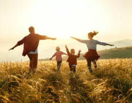 Familie zusammen draußen bei Sonnenuntergang