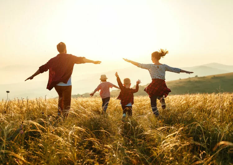 Familie zusammen draußen bei Sonnenuntergang