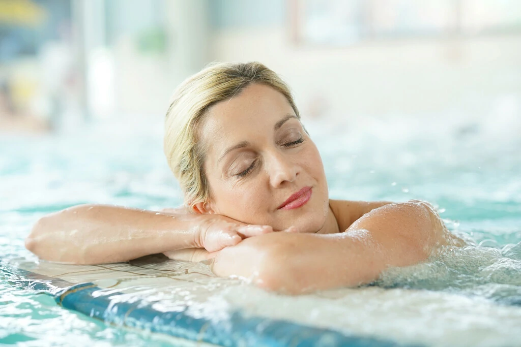 Frau entspannt im Wasser in der Therme