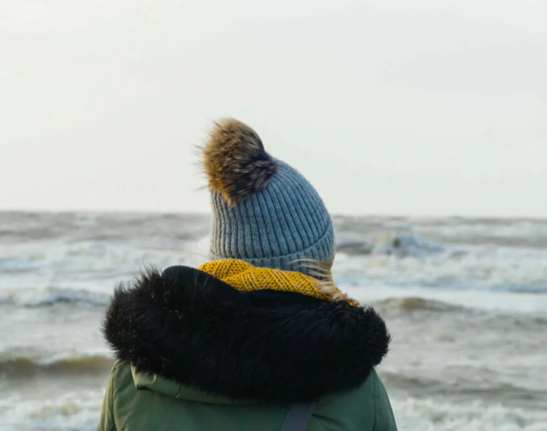 Frau schaut auf die Nordsee am Strand