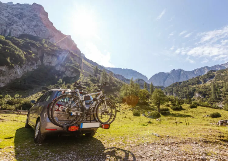 Auto mit Fahrrädern und Berglandschaft