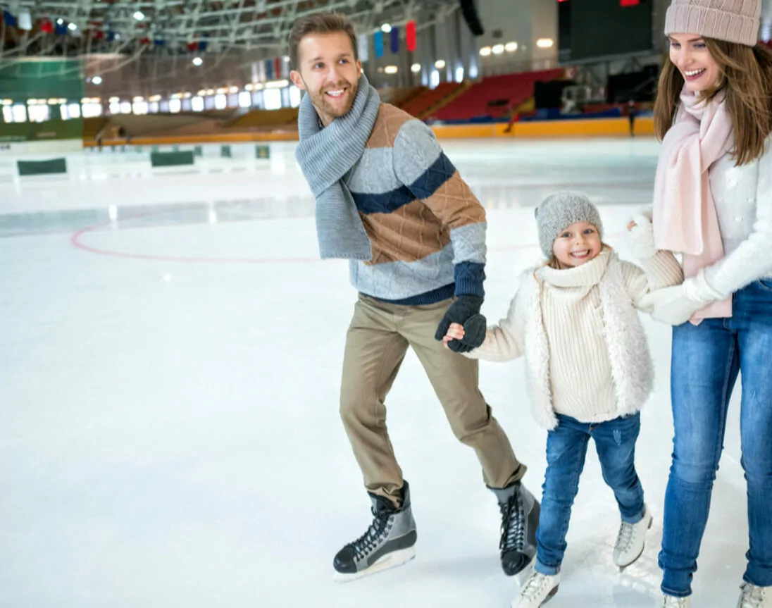 Familie beim Schlittschuh laufen auf der Eisbahn