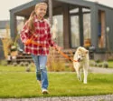 Mädchen spielt mit Hund im Garten