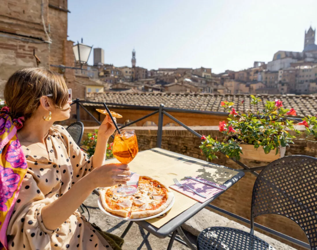 Junge Frau beim Essen in der Altstadt von Siena