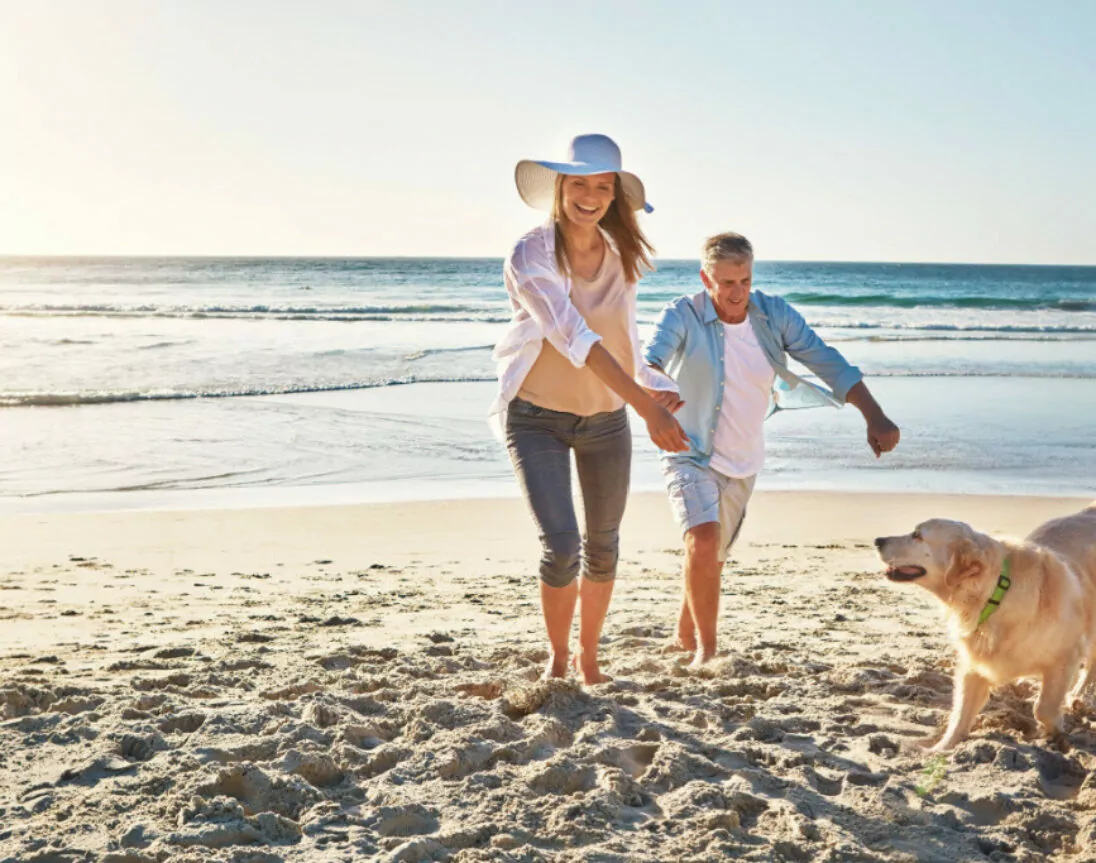 Paar im Urlaub am Meer mit Hund