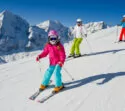 Glückliche Skifahrer während Skiurlaub in Tirol auf verschneiter Piste
