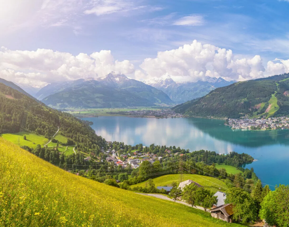 Panoramasicht auf Zell am See, Zeller See und blühende Wiesen im Frühling, Salzburg, Österreich