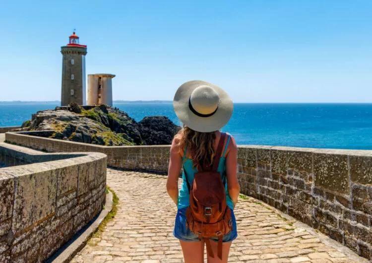 Frau vor Leuchtturm Petit Minou in Plouzane, Bretagne